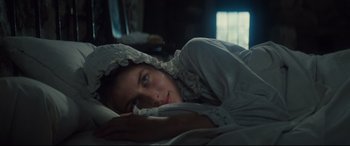Movie still from “Tess” (1979), directed by Roman Polanski – A woman laying in a bed with her eyes closed; Close Up shot, High angle