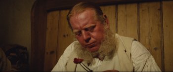 Movie still from “Tess” (1979), directed by Roman Polanski – A man with a long beard holding a flower; Close Up shot, Low angle