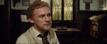 Movie still from “Tess” (1979), directed by Roman Polanski – A person with curly hair wearing a neck tie; Close Up shot, Over the shoulder angle