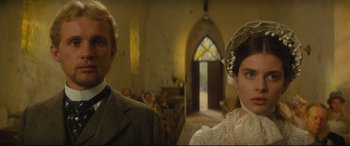 Movie still from “Tess” (1979), directed by Roman Polanski – A man and a woman standing next to each other in front of a church; Close Up shot, Low angle