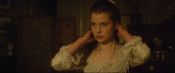 Movie still from “Tess” (1979), directed by Roman Polanski – A young woman in a white dress holding her hands up to her face; Close Up shot, Over the shoulder angle