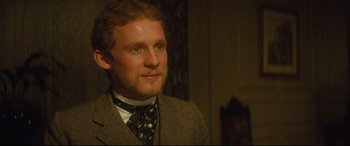 Movie still from “Tess” (1979), directed by Roman Polanski – A man in a suit and tie looking at the camera; Close Up shot, Over the shoulder angle