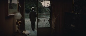 Movie still from “Tess” (1979), directed by Roman Polanski – A man standing in front of an open door; Wide shot, Over the shoulder angle