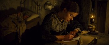 Movie still from “Tess” (1979), directed by Roman Polanski – A woman is writing on a piece of paper; Medium shot, High angle