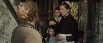 Movie still from “Tess” (1979), directed by Roman Polanski – A group of people standing next to each other in a room; Medium shot, Over the shoulder angle