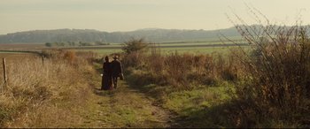 Movie still from “Tess” (1979), directed by Roman Polanski – A man and a woman walking down a dirt road; Extreme Wide shot, High angle
