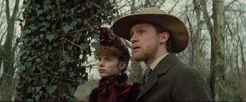 Movie still from “Tess” (1979), directed by Roman Polanski – A man and a woman standing next to each other in front of a tree; Close Up shot, Low angle