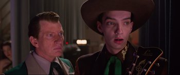 Movie still from “Elvis” (2022), directed by Baz Luhrmann – A man in a green tie and a man in a brown suit and green tie; Close Up shot, Over the shoulder angle