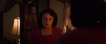 Movie still from “Elvis” (2022), directed by Baz Luhrmann – A woman looking in the mirror in front of a mirror; Close Up shot, Over the shoulder angle