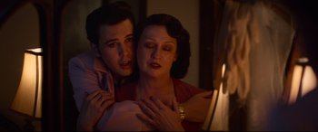 Movie still from “Elvis” (2022), directed by Baz Luhrmann – A man and a woman embracing each other in a dark room; Close Up shot, High angle