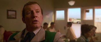 Movie still from “Elvis” (2022), directed by Baz Luhrmann – A person wearing a suit and tie; Close Up shot, Over the shoulder angle