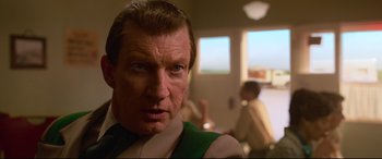 Movie still from “Elvis” (2022), directed by Baz Luhrmann – A person wearing a suit and tie; Close Up shot, Over the shoulder angle