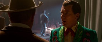 Movie still from “Elvis” (2022), directed by Baz Luhrmann – A man wearing a cowboy hat and a green jacket; Close Up shot, Over the shoulder angle