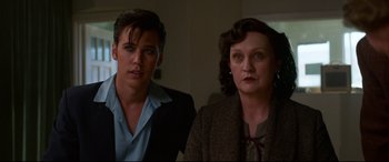 Movie still from “Elvis” (2022), directed by Baz Luhrmann – A man standing next to a woman in a room; Close Up shot, Over the shoulder angle