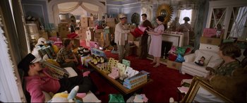 Movie still from “Elvis” (2022), directed by Baz Luhrmann – A group of people standing around a room filled with boxes; Wide shot, High angle