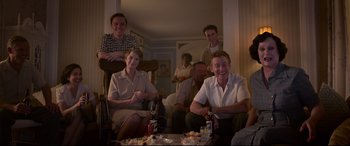 Movie still from “Elvis” (2022), directed by Baz Luhrmann – A group of people sitting around a table with drinks; Medium shot, High angle