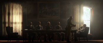 Movie still from “Elvis” (2022), directed by Baz Luhrmann – A group of people sitting at a table in a room; Wide shot, Low angle
