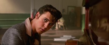 Movie still from “Elvis” (2022), directed by Baz Luhrmann – A young man with his head tilted to the side; Close Up shot, Over the shoulder angle