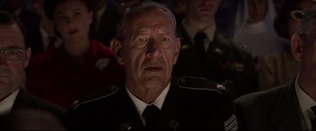 Movie still from “Elvis” (2022), directed by Baz Luhrmann – An older man in a military uniform looking at the camera; Close Up shot, Over the shoulder angle