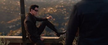 Movie still from “Elvis” (2022), directed by Baz Luhrmann – A man sitting on top of a wooden bench; Wide shot, High angle