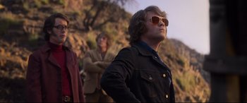 Movie still from “Elvis” (2022), directed by Baz Luhrmann – A man in a jacket and sun glasses looking up; Medium shot, Low angle