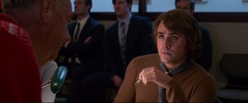 Movie still from “Elvis” (2022), directed by Baz Luhrmann – A group of men sitting in a room; Medium shot, Over the shoulder angle