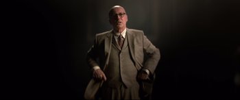 Movie still from “Elvis” (2022), directed by Baz Luhrmann – An older man in a suit and tie holding a cane; Medium shot, Low angle