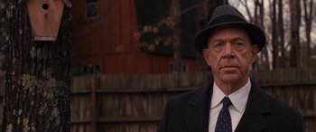 Movie still from “The Accountant” (2016), directed by Gavin O'Connor – An older man wearing a suit and hat; Close Up shot, Over the shoulder angle