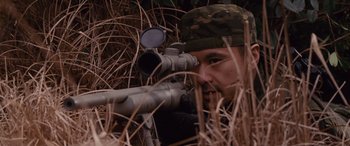 Movie still from “The Accountant” (2016), directed by Gavin O'Connor – A man with a rifle looking through a rifle scope; Close Up shot, High angle