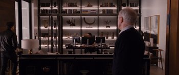 Movie still from “The Accountant” (2016), directed by Gavin O'Connor – A man standing in front of a computer in a room; Wide shot, Over the shoulder angle