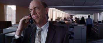 Movie still from “The Accountant” (2016), directed by Gavin O'Connor – A man in a suit and tie talking on a phone in an office; Close Up shot, Over the shoulder angle