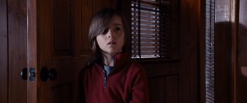 Movie still from “The Accountant” (2016), directed by Gavin O'Connor – A young boy wearing a red jacket in front of a window; Close Up shot, Low angle