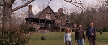 Movie still from “The Accountant” (2016), directed by Gavin O'Connor – Two people are walking in front of a large house; Wide shot, Low angle