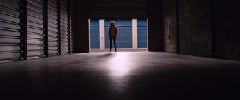 Movie still from “The Accountant” (2016), directed by Gavin O'Connor – A woman standing in a garage with a door open; Extreme Wide shot, Low angle