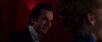 Movie still from “The Age of Innocence” (1993), directed by Martin Scorsese – A person wearing a suit and bow tie; Close Up shot, Over the shoulder angle