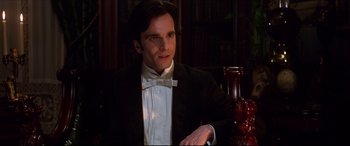 Movie still from “The Age of Innocence” (1993), directed by Martin Scorsese – A man in a tuxedo sitting at a table; Close Up shot, Low angle