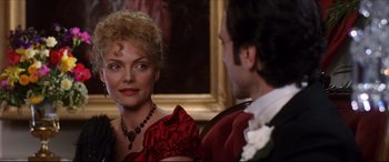 Movie still from “The Age of Innocence” (1993), directed by Martin Scorsese – A man and a woman are sitting in front of a painting; Close Up shot, Over the shoulder angle