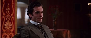 Movie still from “The Age of Innocence” (1993), directed by Martin Scorsese – A person wearing a suit and tie; Close Up shot, Over the shoulder angle