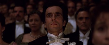 Movie still from “The Age of Innocence” (1993), directed by Martin Scorsese – A person wearing a suit and bow tie; Close Up shot, Low angle