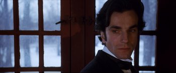 Movie still from “The Age of Innocence” (1993), directed by Martin Scorsese – A person wearing a suit and bow tie; Close Up shot, Over the shoulder angle