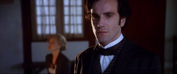 Movie still from “The Age of Innocence” (1993), directed by Martin Scorsese – A man wearing a suit and a bow tie; Close Up shot, Low angle