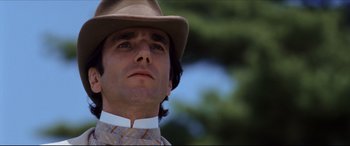 Movie still from “The Age of Innocence” (1993), directed by Martin Scorsese – A person wearing a hat with trees in the background; Close Up shot, Low angle