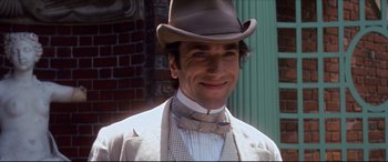 Movie still from “The Age of Innocence” (1993), directed by Martin Scorsese – A person wearing a hat and a bow tie; Close Up shot, Low angle