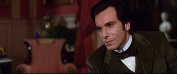 Movie still from “The Age of Innocence” (1993), directed by Martin Scorsese – A person wearing a suit and bow tie; Close Up shot, Over the shoulder angle