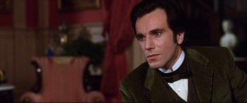 Movie still from “The Age of Innocence” (1993), directed by Martin Scorsese – A person wearing a suit and tie; Close Up shot, Over the shoulder angle