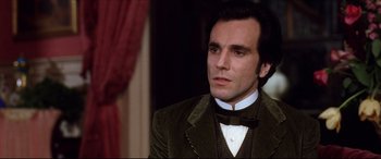 Movie still from “The Age of Innocence” (1993), directed by Martin Scorsese – A person wearing a suit and bow tie; Close Up shot, Over the shoulder angle
