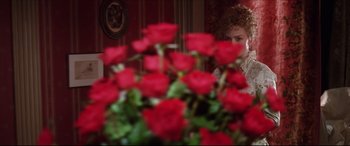 Movie still from “The Age of Innocence” (1993), directed by Martin Scorsese – A woman sitting in front of a bouquet of red roses; Medium shot, Over the shoulder angle