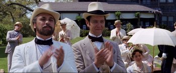 Movie still from “The Age of Innocence” (1993), directed by Martin Scorsese – A group of men in suits and hats clapping; Medium shot, Over the shoulder angle