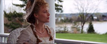 Movie still from “The Age of Innocence” (1993), directed by Martin Scorsese – A woman wearing a white dress and pearls looking out of a window; Medium shot, Over the shoulder angle
