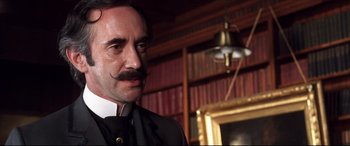 Movie still from “The Age of Innocence” (1993), directed by Martin Scorsese – A man in a suit and tie with a handlebar mustache; Close Up shot, Low angle